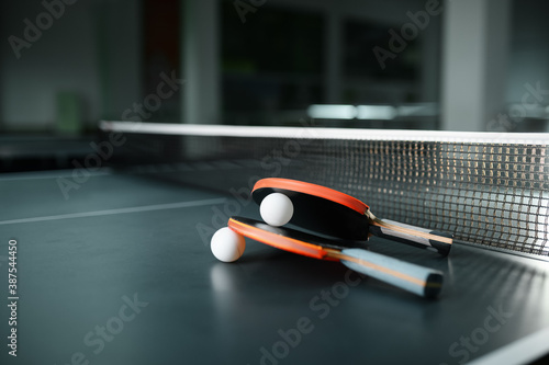 Ping pong rackets and ball at the net closeup