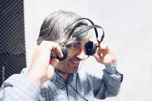 Stylish middle-aged man puts on headphones to check his hearing.Copy space.Hearing care concept.