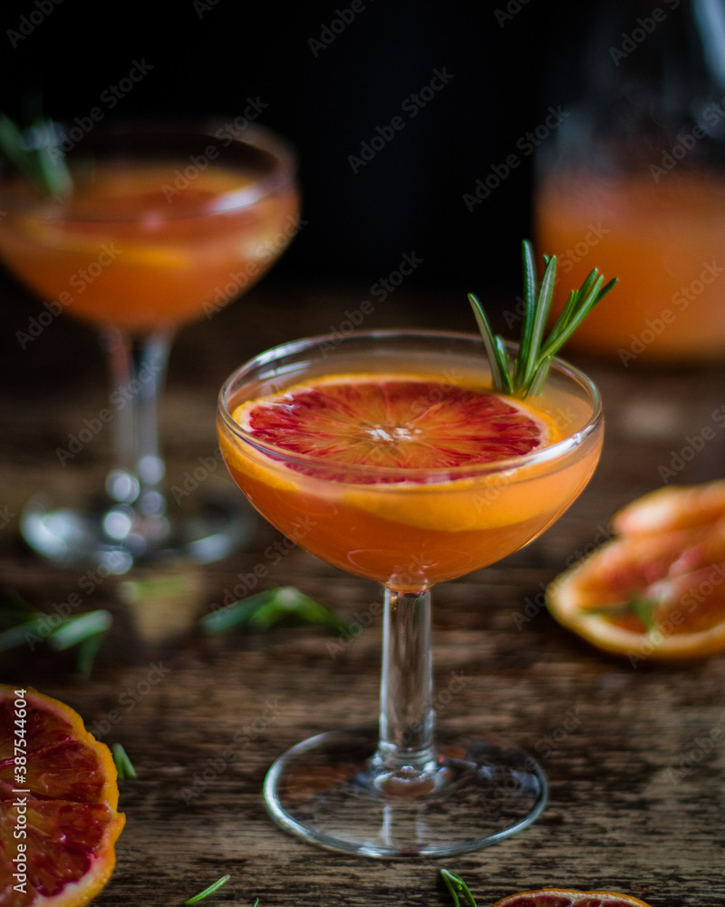 Drink of red oranges with the addition of rosemary on a wooden background Drink of red oranges with the addition of rosemary on a wooden background