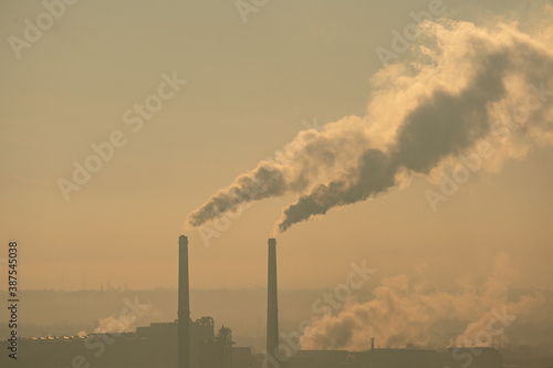 Smoking factory chimneys in morning backlit