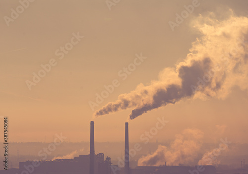 Smoking factory chimneys in morning backlit