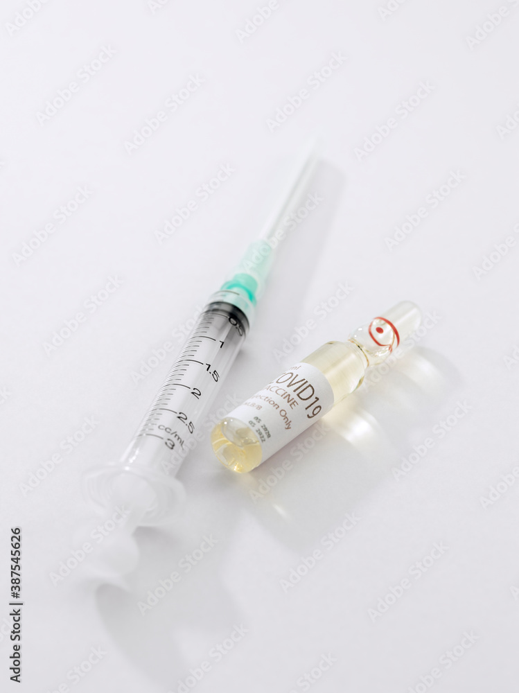 Close up view of the ampule with medicine and syringe on white back Close up view of the ampule with medicine and syringe on white back