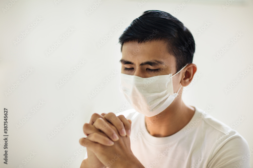 Asian man in face mask praying for Asian man in face mask praying for