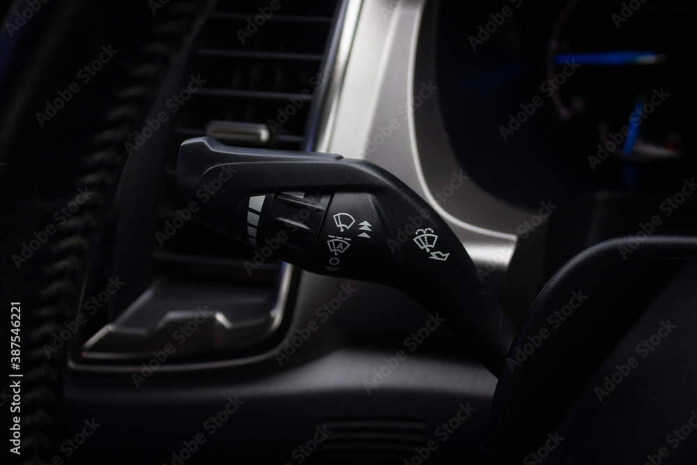 Windscreen wiper control switch in car. Wipers control. Modern car interior detail. adjusting speed of screen wipers in car. Windscreen wiper control switch in car. Wipers control. Modern car interior detail. adjusting speed of screen wipers in car.