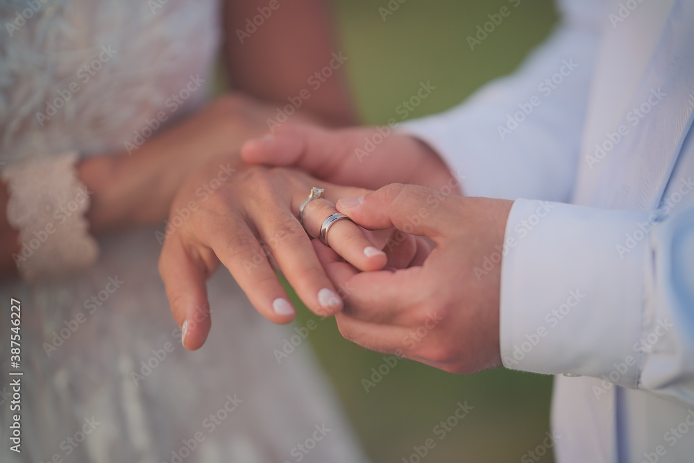 Close-up of a man's hand putting a ring on a woman's hand. Close-up of a man's hand putting a ring on a woman's hand.