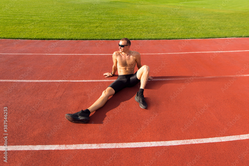 Obraz premium Runner resting on the track at the stadium