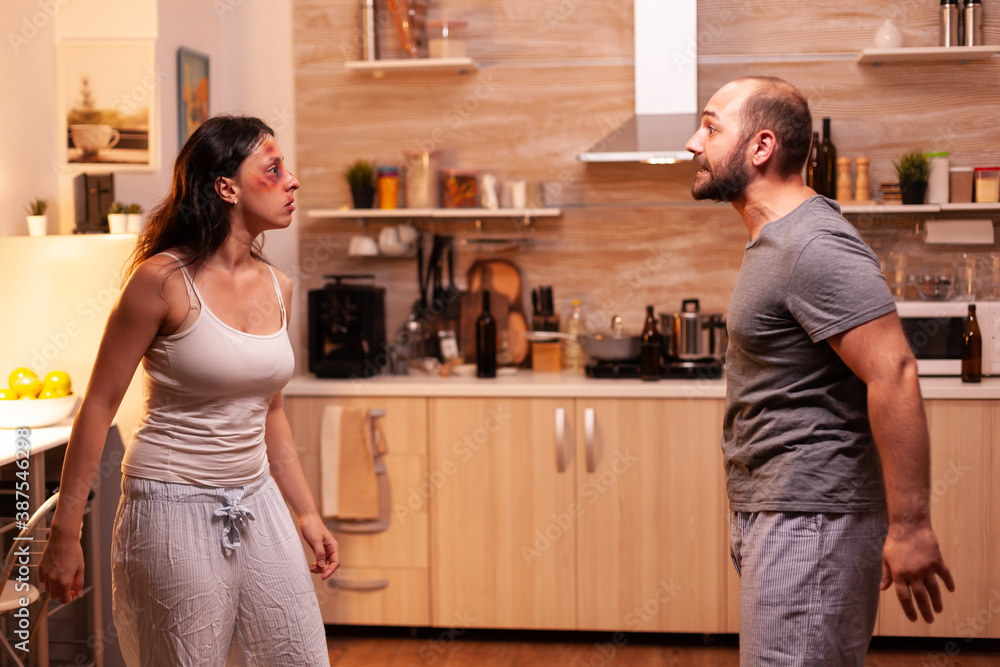 Abusive husband threatening wife covered with bruises. Traumatised helpless terrified vulnerable woman suffering injury from violent alcoholoic brutal man. Abusive husband threatening wife covered with bruises. Traumatised helpless terrified vulnerable woman suffering injury from violent alcoholoic brutal man.