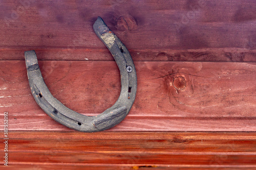 An old horseshoe from a horse's hoof hangs on the wall. Background. Copy space.