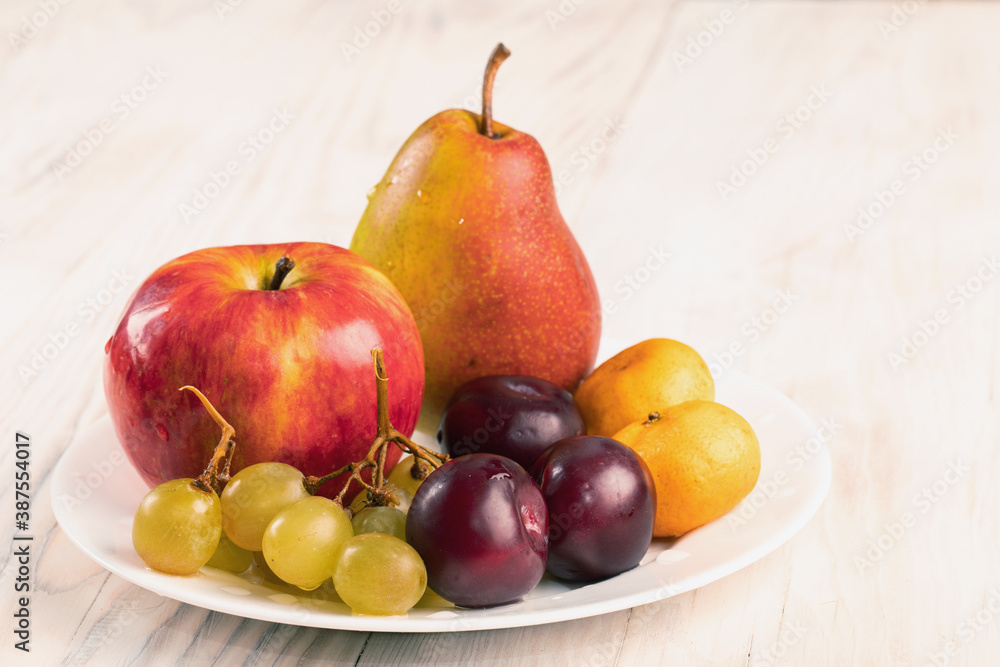 Assorted fruits plate with fruit on wooden table Autumn harvest Assorted fruits plate with fruit on wooden table Autumn harvest