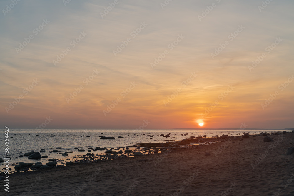 Sunset on baltic sea beach with rocks in sand Sunset on baltic sea beach with rocks in sand