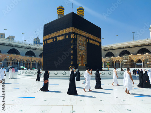 MECCA, SAUDI ARABIA , OCTOBER 22, 2020 - Pilgrims circle the Kaaba in Masjid al-Haram - umrah Fewer Muslims people Socially Distanced corona virus wearing face mask
