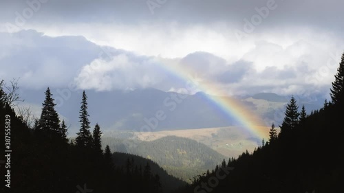 Rainbow after the rain over the forest. time lapse. Mountain landscape, Rainbow in the Mountains and Dramatic Clouds