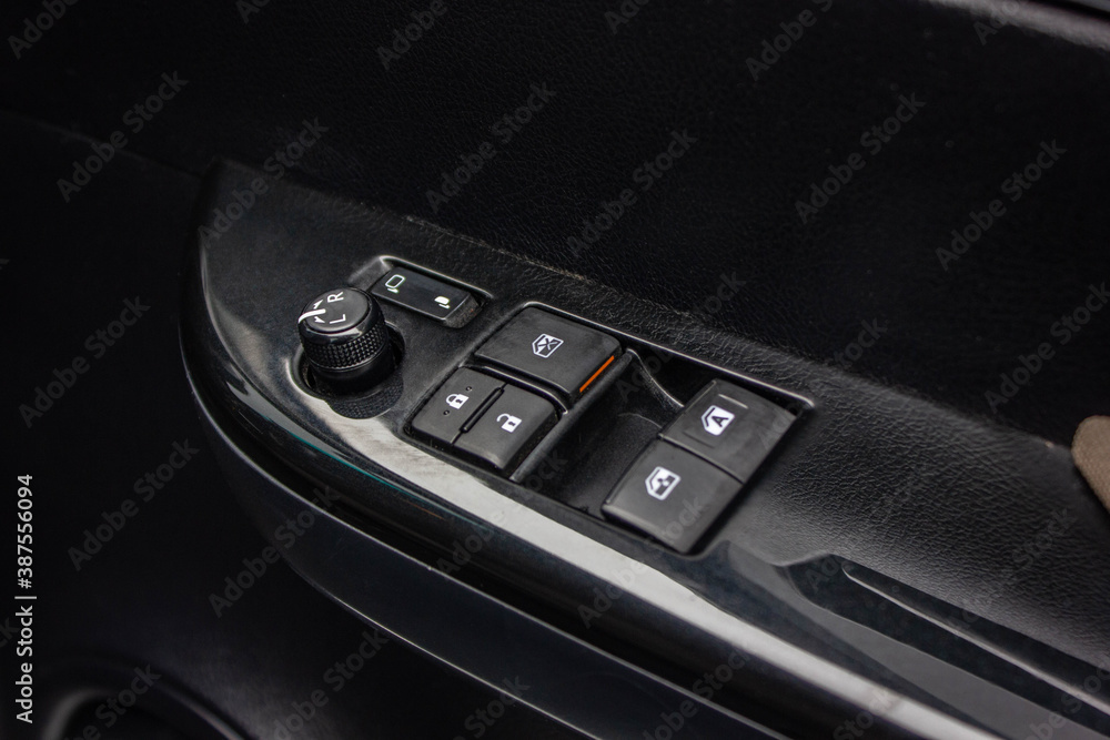 Car arm rest with Control Panel. Door Lock & Mirror Control. window adjustment buttons, door lock. Photography of a modern car.