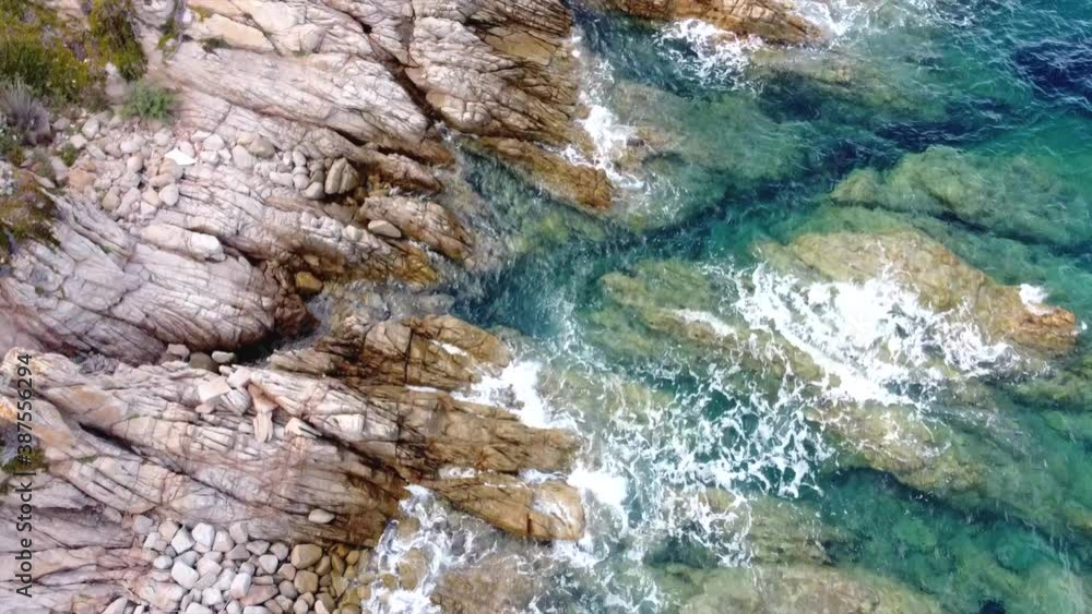 Aerial view of ocean waves hitting rocky coastline adorning one of the most beautiful seaside spot in Santa Teresa Gallura, northern Sardinia, Italy Aerial view of ocean waves hitting rocky coastline adorning one of the most beautiful seaside spot in Santa Teresa Gallura, northern Sardinia, Italy