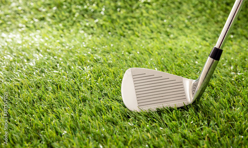 Golf stick on green grass golf course, close up view.