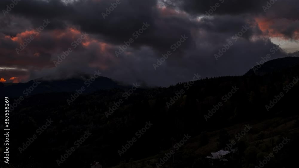 Dramatic Time lapse of morning fog in the autumn mountains. Clouds rolling over mountains turning into fog in the dusk. Sunrise over mountain village. Dramatic Time lapse of morning fog in the autumn mountains. Clouds rolling over mountains turning into fog in the dusk. Sunrise over mountain village.