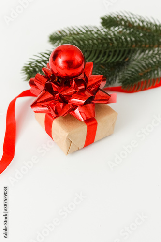 Holiday Gift Box with red bow and pine branch on white background. New years greeting card