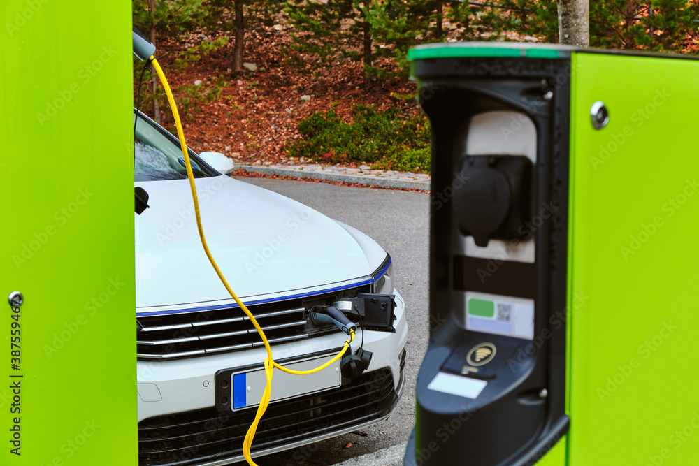 The modern electric car charged on the car parking in National Park in Finland.