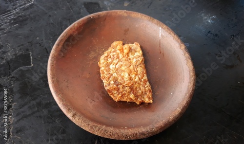 brown tempe or fried tempe on bowl or tempe goreng disajikan di wadah dari tanah liat