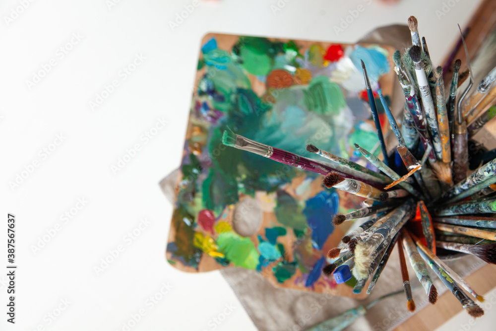 Fototapeta premium picking oil paintbrushes near canvas in workshop