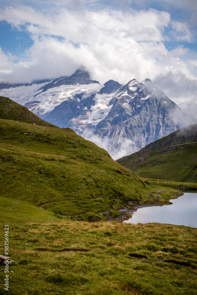 Valais Alps near Grindelwald with Jungfrau mountain in the distance on a cloudy summer day. 