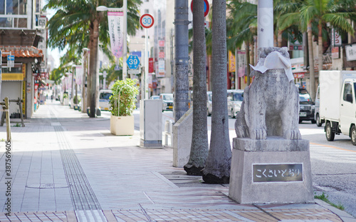 マスクをつけたシーサーと人通りの少ない沖縄県那覇市の国際通り photo