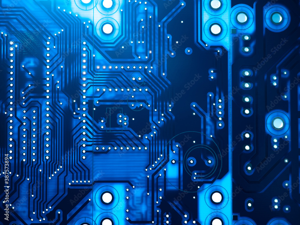Blue background is made up of PCB. Abstract printed circuit Board close up.  PCB productin concept. Dark background on theme of electronics. Light  shines through circuit board. Computer components. Stock Photo |