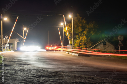 Night railway crossing with passing cars © Максим Травкин