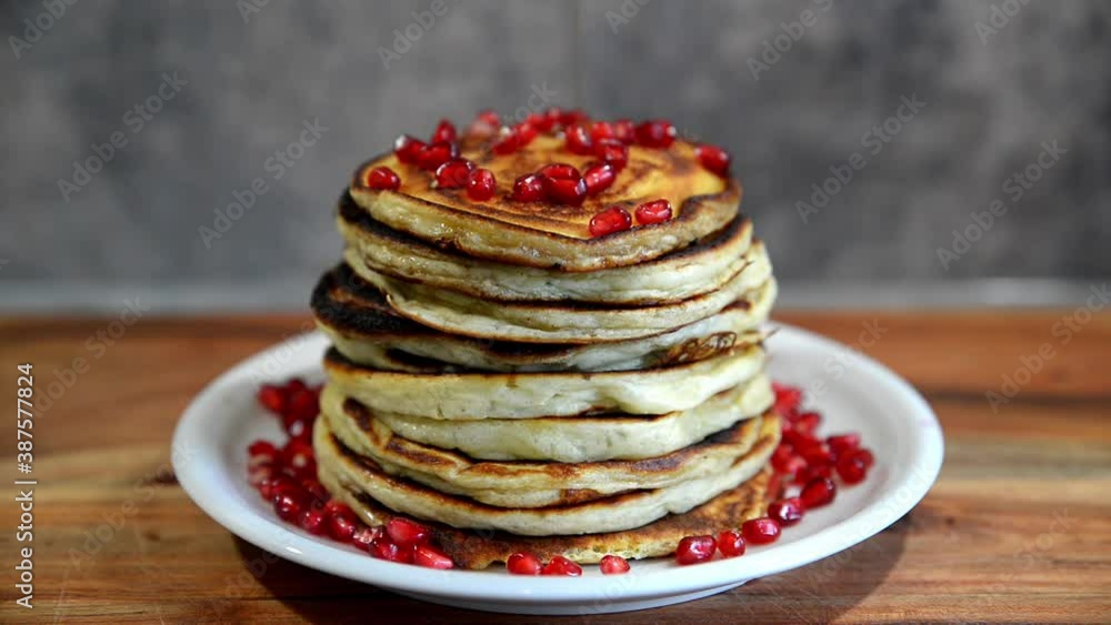 Stack of american pancakes with pomegranate and maple sirup. Pile of pancakes with maple sirup and berries. Stack of american pancakes with pomegranate and maple sirup. Pile of pancakes with maple sirup and berries.