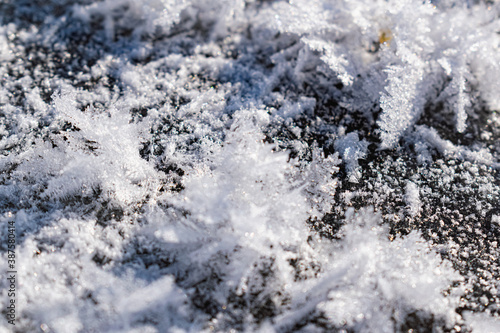 Snowy white background with frosty crystals and curly snowflakes close-up. Winter is a cold season with a blinding white bright color © Анна Иванова