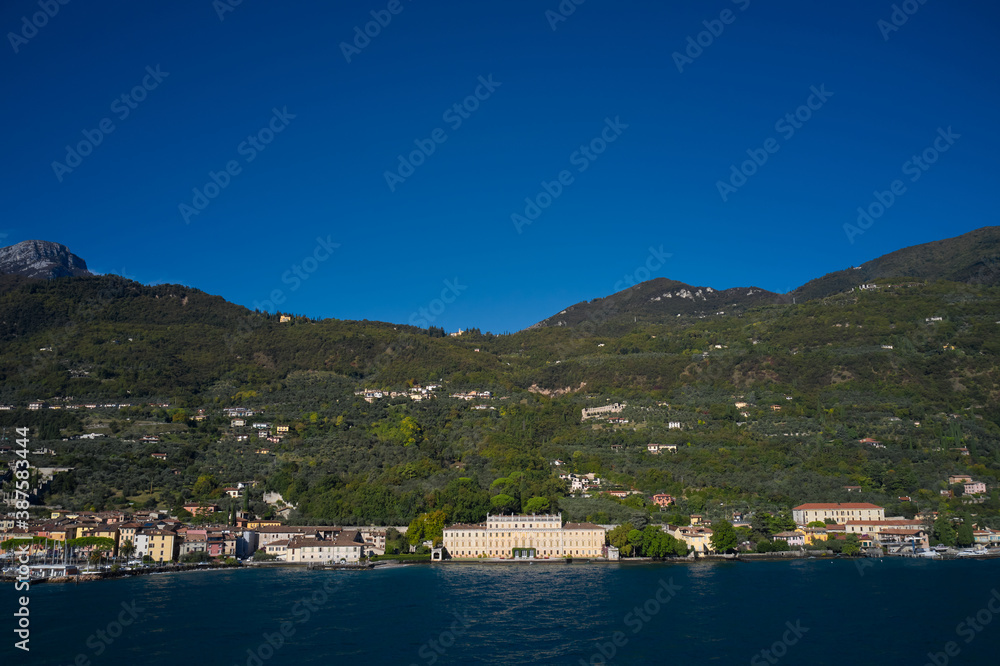 Panoramic view of the sights on Lake Garda Italy. Aerial view of architecture on Lake Garda. Ancient villa on Lake Garda in the background Alps and blue sky. Panoramic view of the sights on Lake Garda Italy. Aerial view of architecture on Lake Garda. Ancient villa on Lake Garda in the background Alps and blue sky.