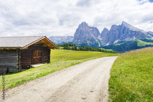 Alpe di Siusi or Seiser Alm, wooden huts and trail. Dolomites Alps, South tyrol, Italy. 