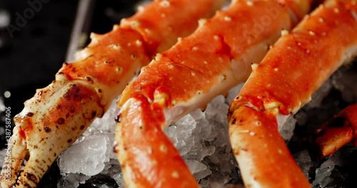 Boiled crab with ice rotates. On a black background.