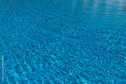 Blue water in the pool with solar reflections. Swimming pool. Water reflex texture from the pool