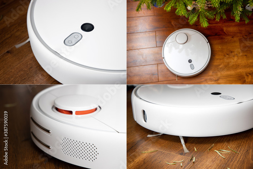 Round white robot vacuum cleaner does its work around the house. Cleaning the house with a robotic vacuum cleaner. photo