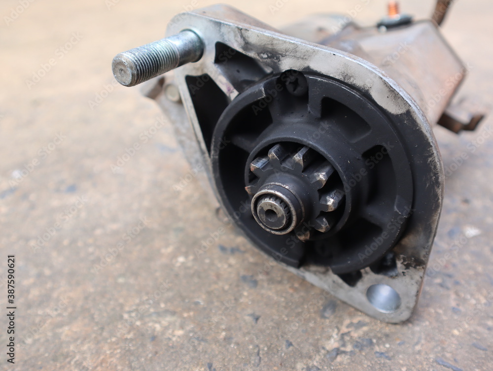 Old automotive starter motor place on the concrete floor Old automotive starter motor place on the concrete floor