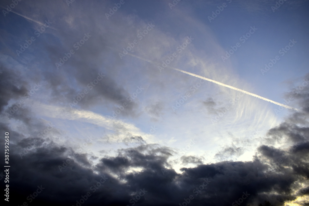 heavy clouds and a trail from a flying plane heavy clouds and a trail from a flying plane