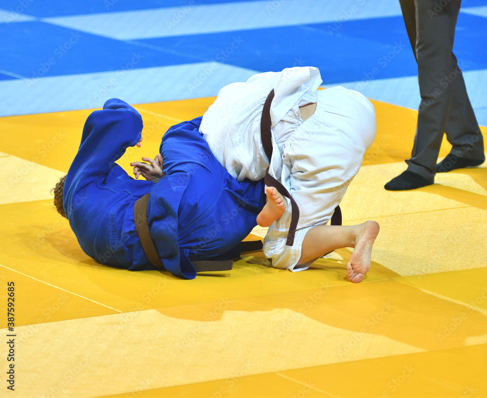 Two Girls judoka in kimono compete on the tatami Two Girls judoka in kimono compete on the tatami