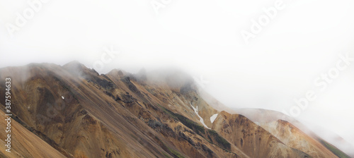 Panoramic view of surreal rhyolite mountains covered in clouds along the laugavegur trail in the highlands of Iceland