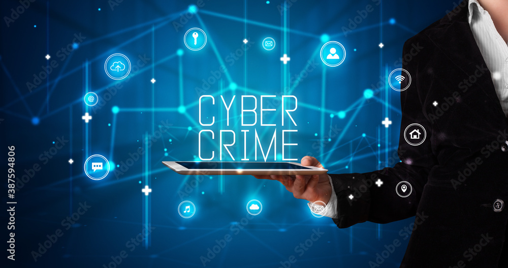 Young business person working on tablet and shows the digital sign: CYBER CRIME Young business person working on tablet and shows the digital sign: CYBER CRIME
