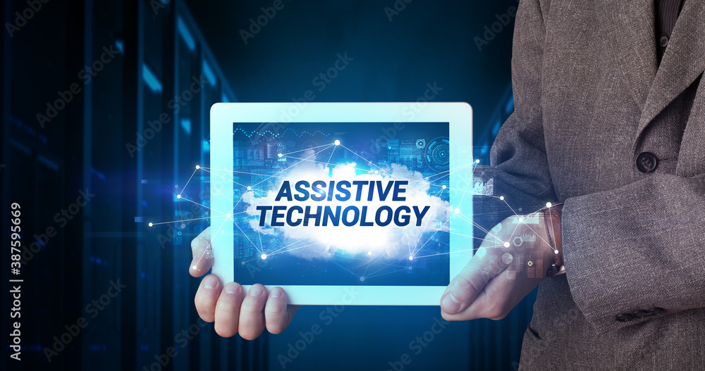 Young business person working on tablet and shows the inscription: ASSISTIVE TECHNOLOGY Young business person working on tablet and shows the inscription: ASSISTIVE TECHNOLOGY