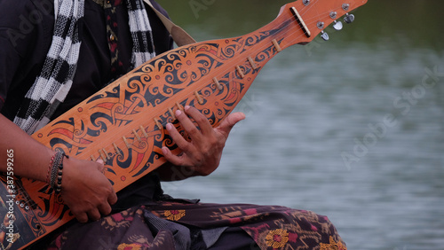 A man's hand playing a traditional musical instrument