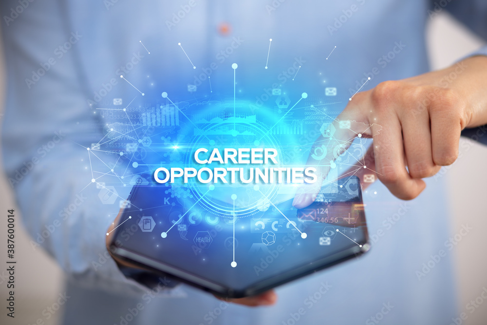 Businessman holding a foldable smartphone with CAREER OPPORTUNITIES inscription, new business concept Businessman holding a foldable smartphone with CAREER OPPORTUNITIES inscription, new business concept