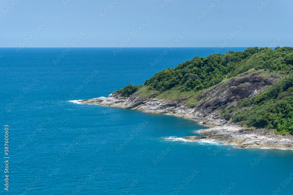 The landscape of the coast line of the famous tourist spot of Phuket island Thailand, the waves hit on the rock shore in the mid-summer day