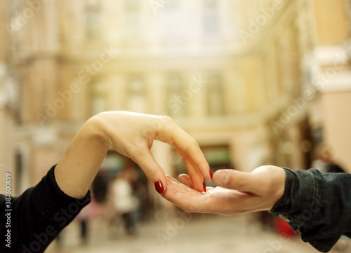 Love concept. Hands of a couple in love on the background of urban architecture