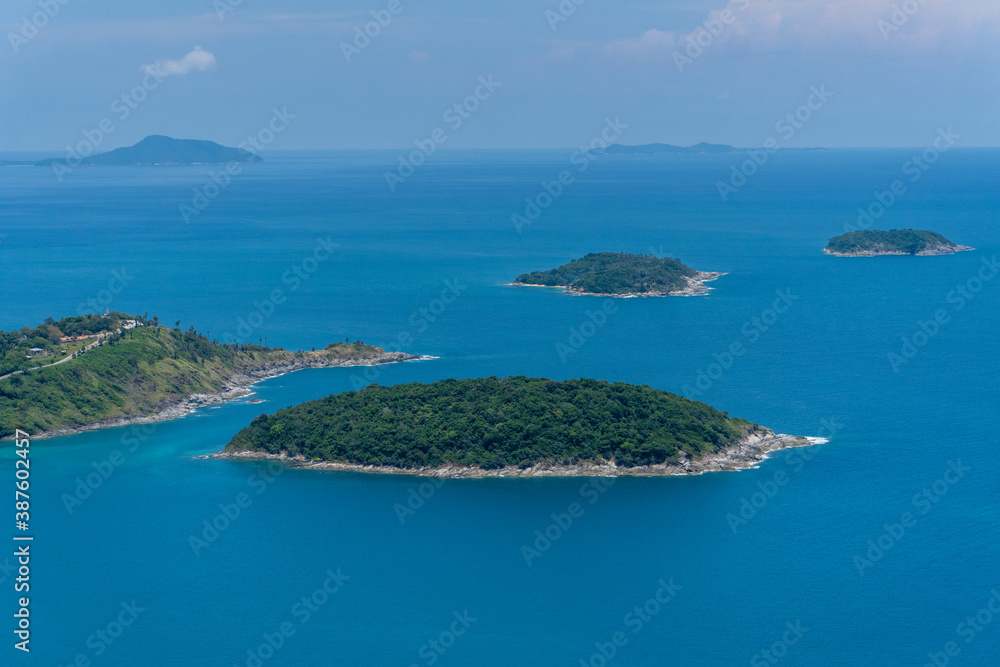 The seascape top view group of the islands in Phuket Thailand Asia in the mid holiday summer with the deep blue ocean and clear sky, the forest full of tropical plam trees naturally grow in the cliff