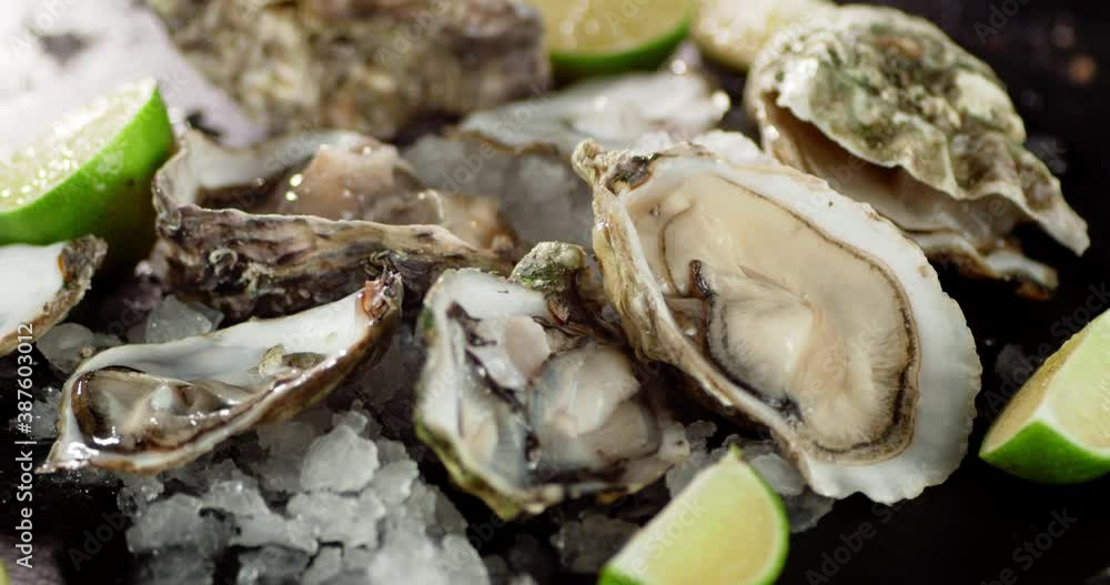 Oysters with sliced lime and ice rotate.