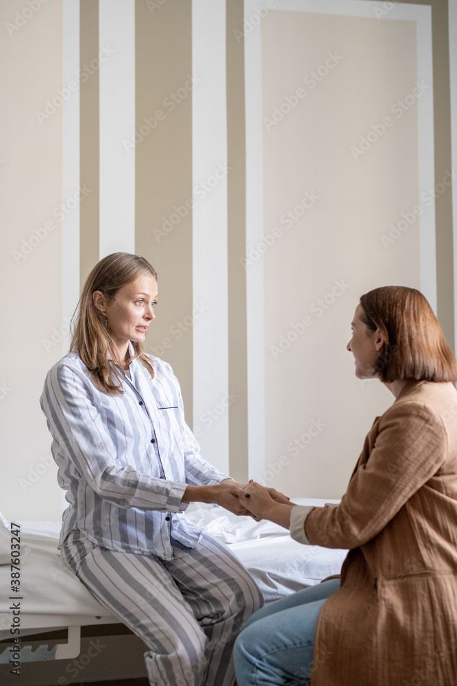© pressmaster - Young patient of covid hospital sitting in front of friend during conversation © pressmaster - Young patient of covid hospital sitting in front of friend during conversation