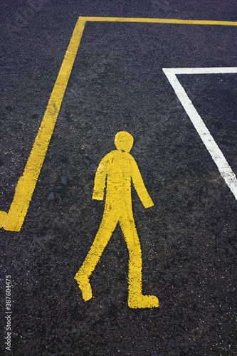 universal iconic shape pedestrian crossing with painted sign in bright yellow 