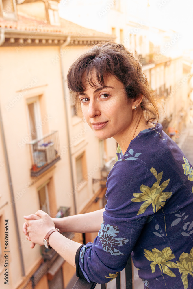 Portrait of beautiful young woman on her town centre apartment balcony, Madrid, Spain